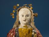 an image of a doll made of a woman with flowers on her head