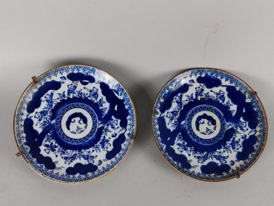 une paire d'assiettes bleues et blanches sur lesquelles sont représentés un homme et une femme