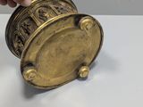 a person holding a brass object on a white table