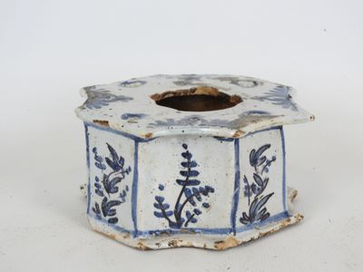 un petit vase bleu et blanc posé sur une surface blanche