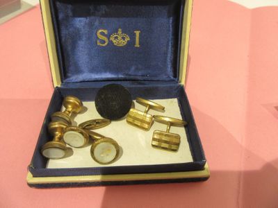 a box with a set of cufflinks and a pair of cufflinks in it