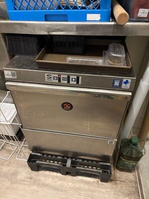 a silver dishwasher sitting on a counter in a kitchen