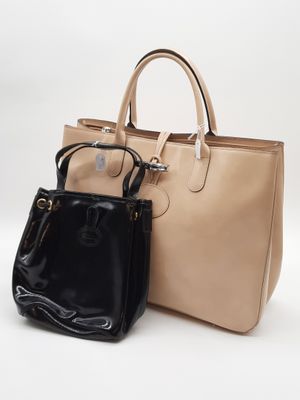 un sac à main beige et noir et un porte-monnaie noir sur fond blanc
