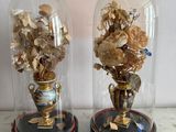 two vases with flowers inside of them sitting on a table