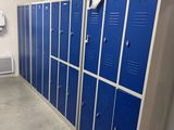 plusieurs casiers bleus dans le couloir d'un immeuble