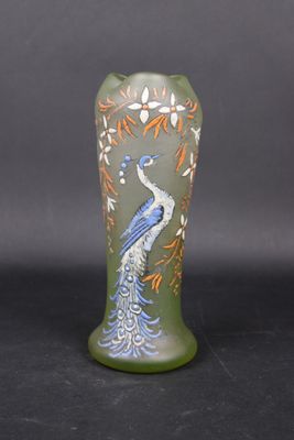 a green vase with a blue and orange peacock on it