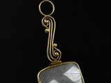 a close up of a gold plated pendant with a faceted faceted quartz stone