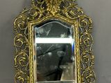 a mirror hanging on the wall with a gold frame