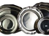 a lot of silver plates that are sitting on a table