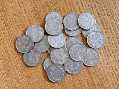 un tas de pièces d'argent posé sur une table en bois