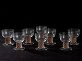 six verres à vin sont alignés sur une surface noire
