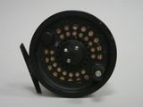 a close up of a fishing reel on a white surface