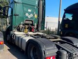 a large green semi truck parked in a parking lot