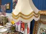 une table sur laquelle se trouvent une lampe et des assiettes, dans une pièce
