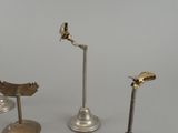 three different types of bird figurines on stands on a white surface