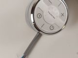 a close up of a clock on a white surface with wires