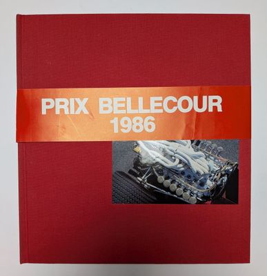 une image représentant un livre rouge sur lequel figure l'illustration d'une voiture