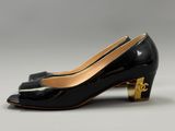 a pair of black and gold shoes with a gold heel