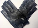 une paire de gants en cuir noir posée sur une table blanche