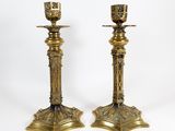 a pair of brass candlesticks on a white background