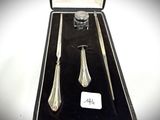 two silver spoons and a knife in a black box