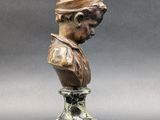 a bronze bust of a woman with a turban on her head