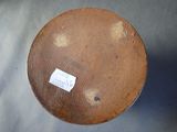 a brown bowl with a sticker on it sitting on a table