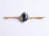 a close up of a blue stone on a gold bobby pin