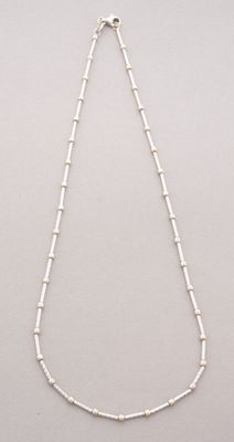 a white necklace with a long chain that has beads on it