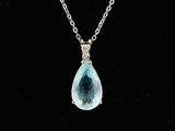 un collier composé d'une pierre bleue en forme de larme montée sur une chaîne en argent