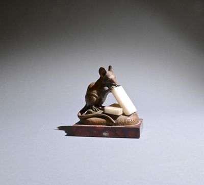 a small figurine of a mouse holding a piece of paper