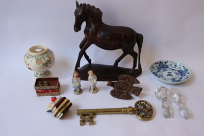 une figurine de cheval posée sur une table, à côté d'autres objets