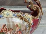 a vase with a painting on it sitting on a table