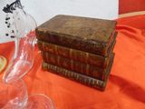 a stack of books sitting on a table next to a glass vase