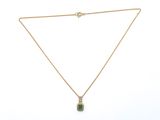 a gold necklace with a green stone pendant on a chain