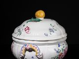 a white bowl with a lid with flowers and a bird on it