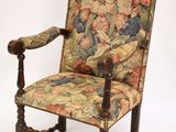 une chaise dont le dossier et les accoudoirs sont recouverts d'un tissu à motifs floraux