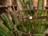 many green glass bottles in a metal holder