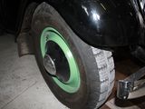 a black car with a green rim parked in a garage