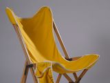 une chaise pliante jaune recouverte d'une couverture jaune