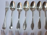 a lot of silver spoons and forks on the table