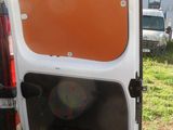 a white van with an orange door open in the grass