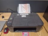 une imprimante posée sur un bureau, à côté d'un ordinateur portable