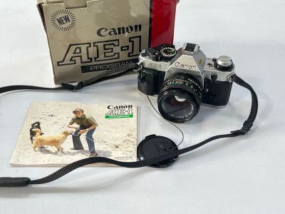 un appareil photo, un livre et une courroie d'appareil photo posés sur une table