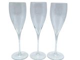 three clear wine glasses sitting next to each other on a white surface