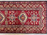 a close up of a red rug on a white floor