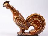 une figurine représentant un coq sur fond blanc