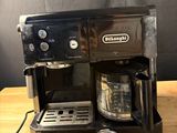 a black coffee maker sitting on a wooden table