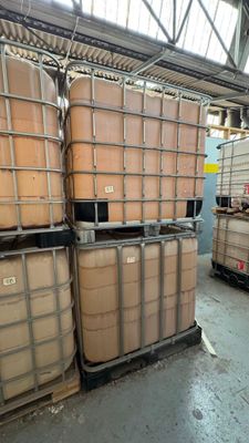 une grande quantité de fûts empilés sur des palettes dans un entrepôt