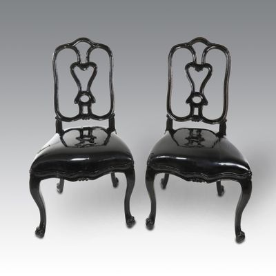 pair of black painted chairs with black leather upholstered seats